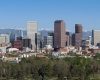 A panoramic view of a city skyline with mountains in the background.